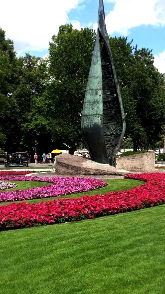 sculpture surrounded by red flowers